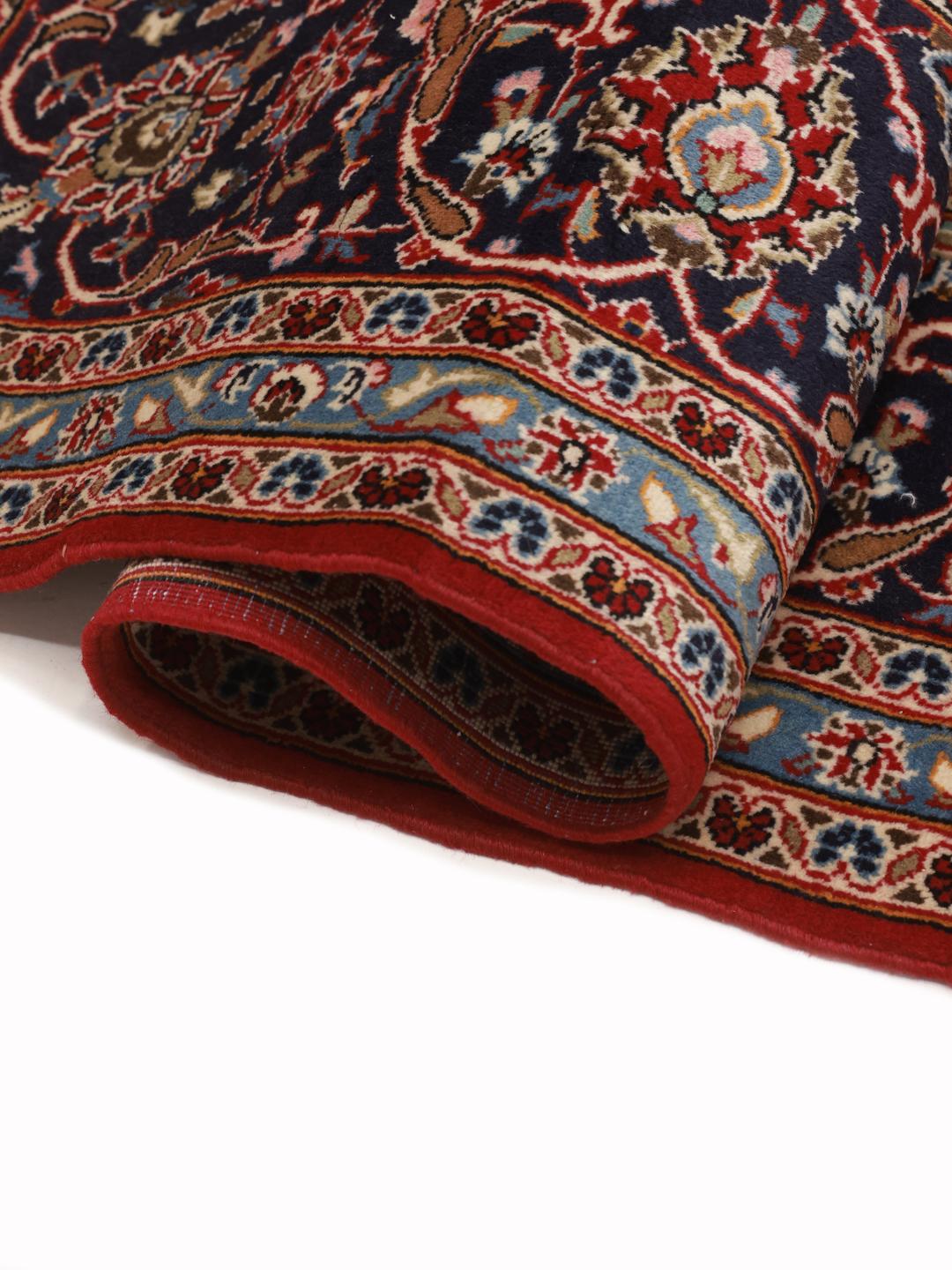 A hand-knotted red Keshan rug from the Middle East with a floral medallion pattern.