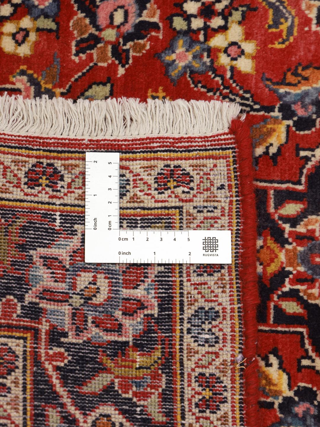 A hand-knotted Middle Eastern Keshan runner in red with floral medallion patterns.
