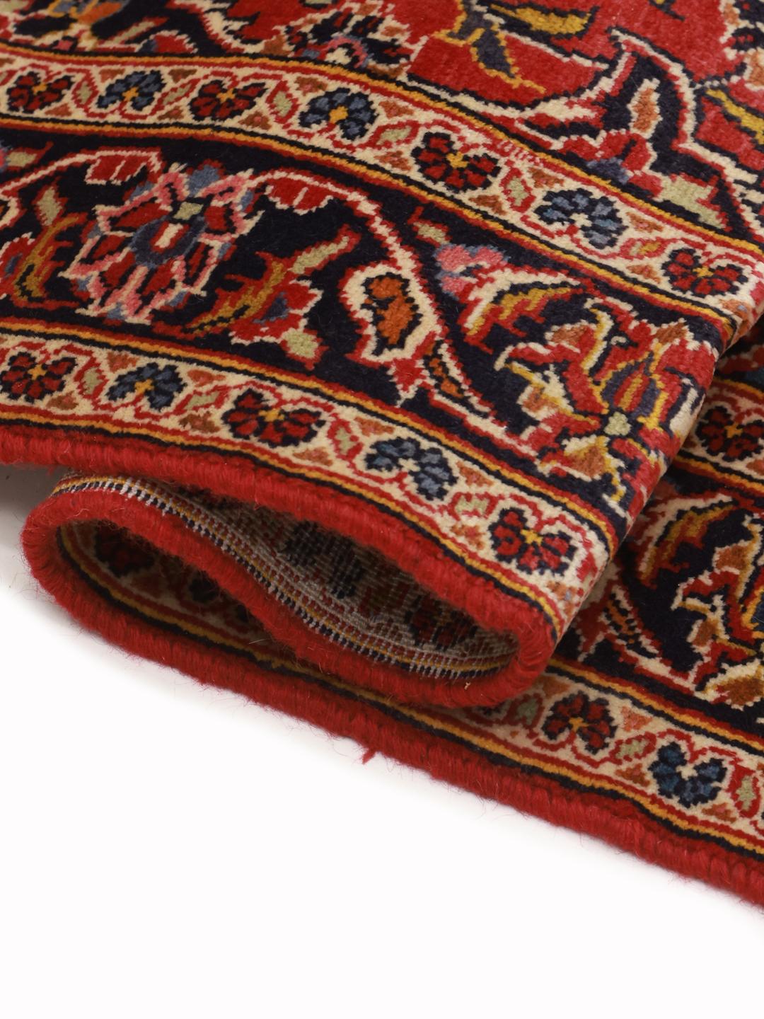 A hand-knotted Middle Eastern Keshan runner in red with floral medallion patterns.