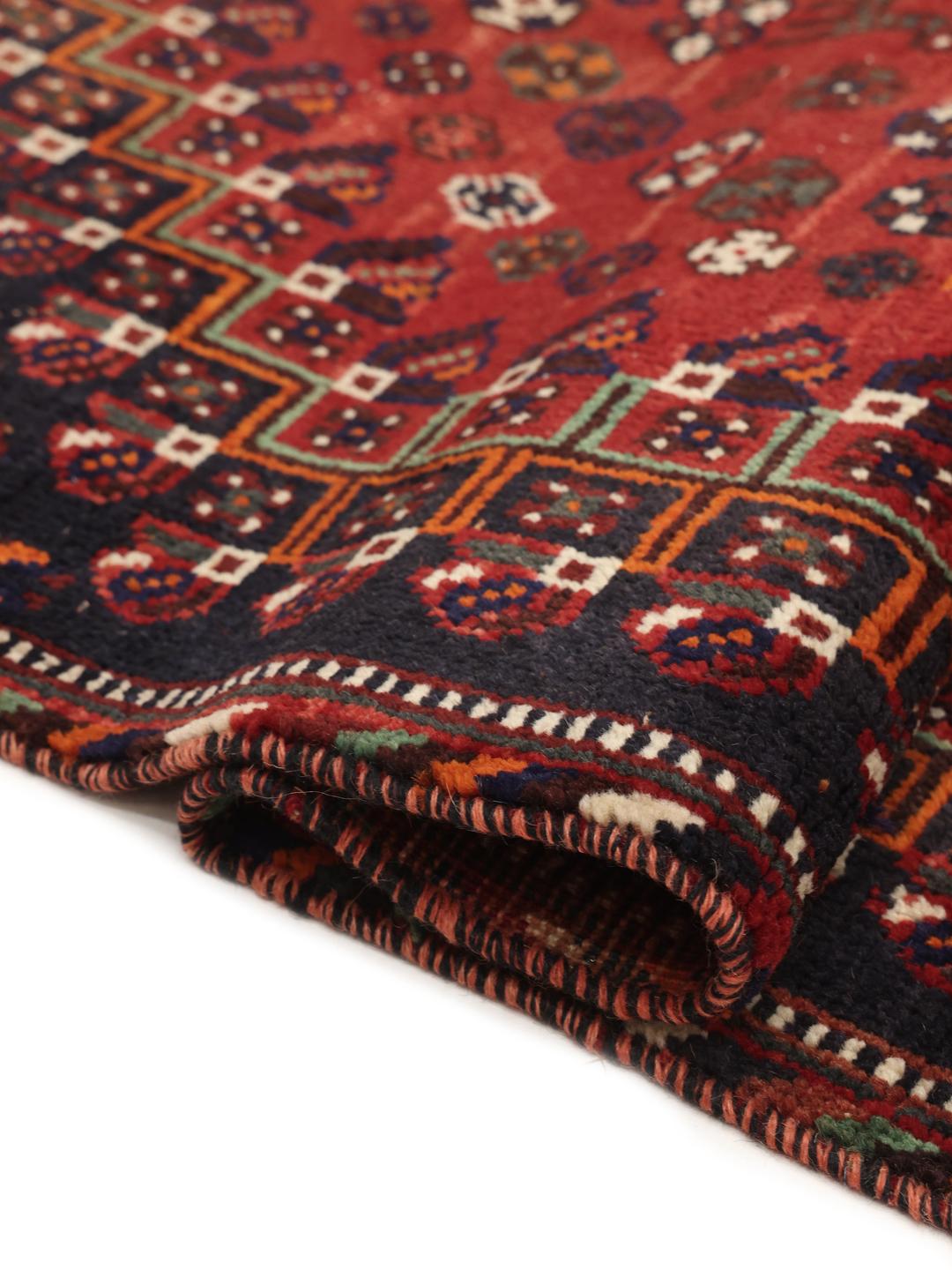 A hand-knotted Ghashghai rug from the Middle East featuring a vibrant red and black colour scheme.
