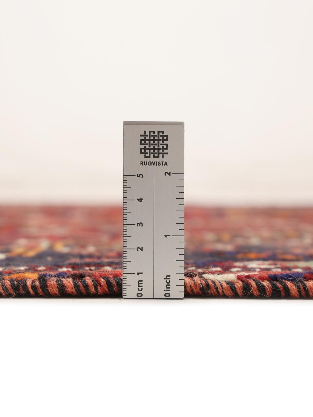 A hand-knotted Ghashghai rug from the Middle East featuring a vibrant red and black colour scheme.