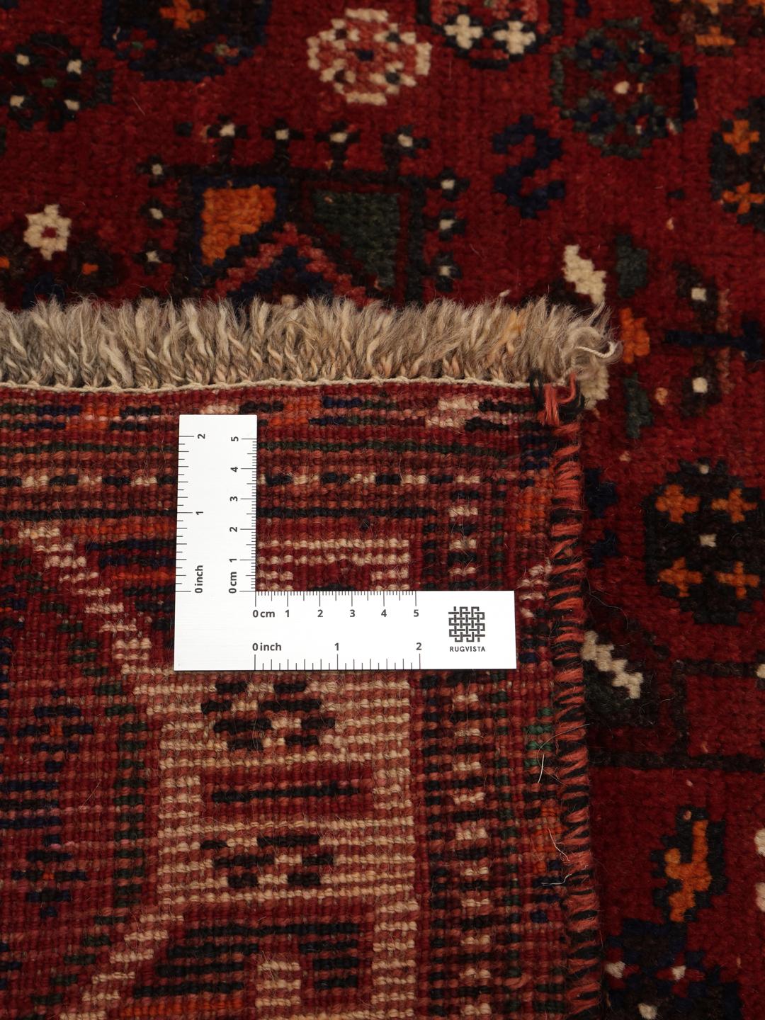 A hand-knotted Ghashghai rug from the Middle East featuring a vibrant red and black colour scheme.