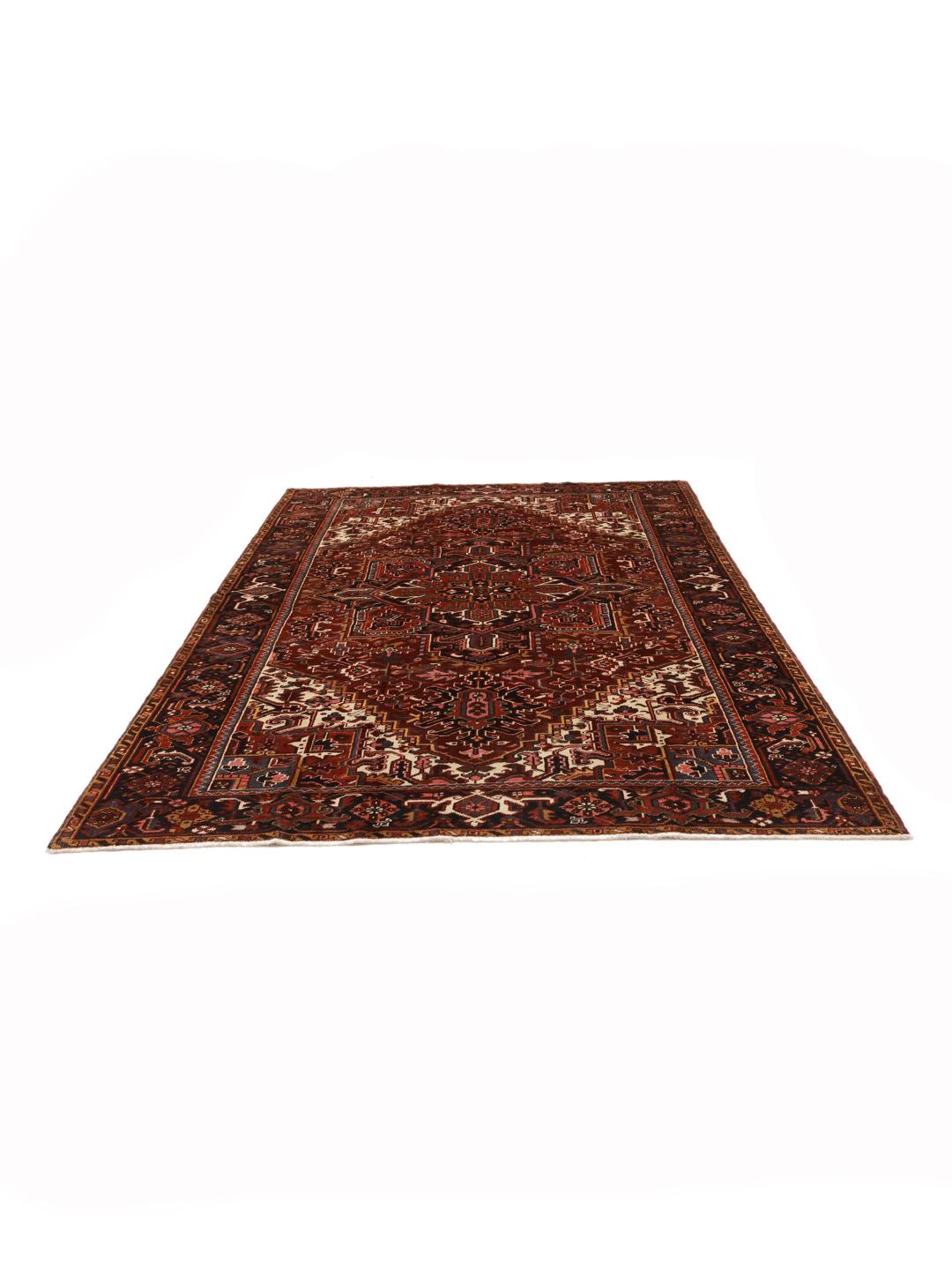 A hand-knotted Heriz rug from the Middle East in deep red and dark blue tones.