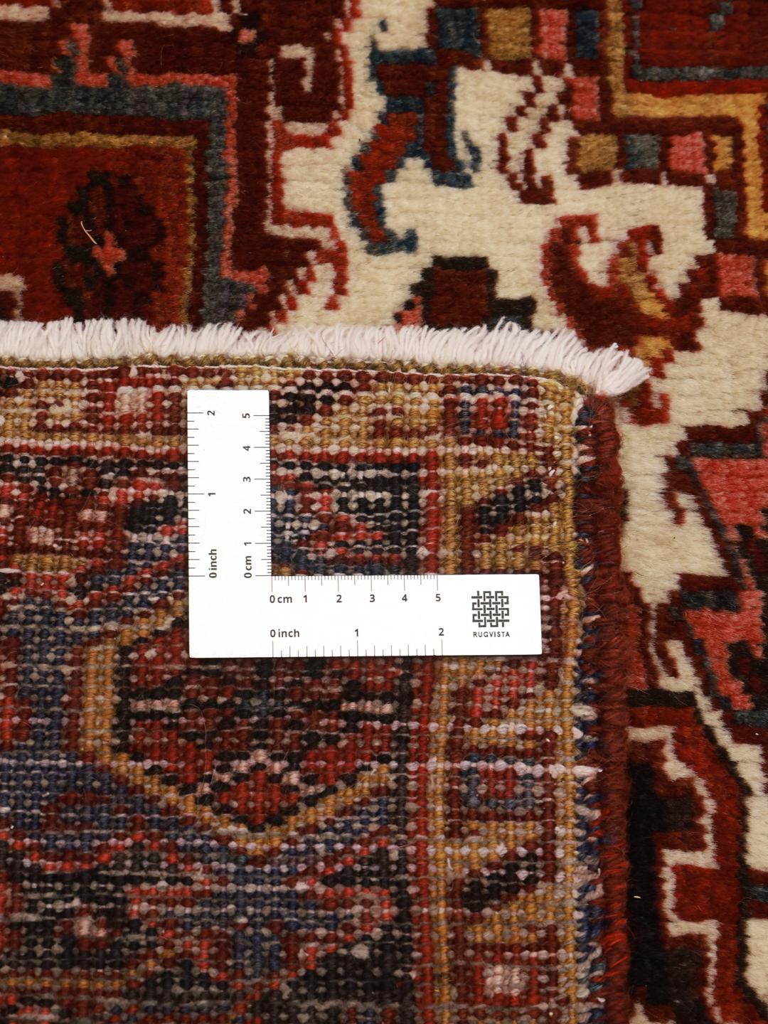 A hand-knotted Heriz rug from the Middle East in deep red and dark blue tones.