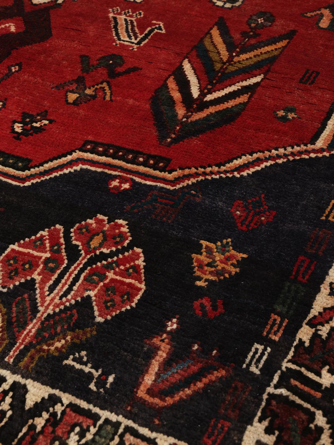 Hand-knotted Shiraz rug from the Middle East in deep red and dark blue tones