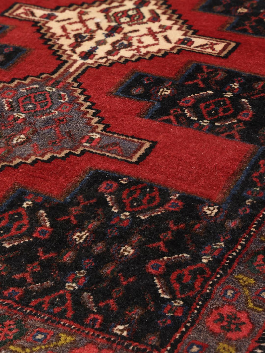 Hand-knotted Senneh rug from the Middle East in red and black