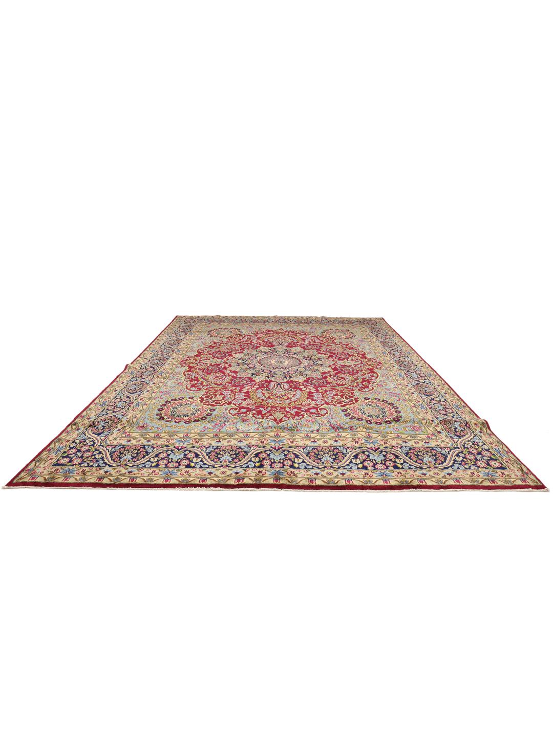 Een groot rechthoekig Kerman-tapijt uit het Midden-Oosten met een levendig rood en blauw bloemenpatroon.