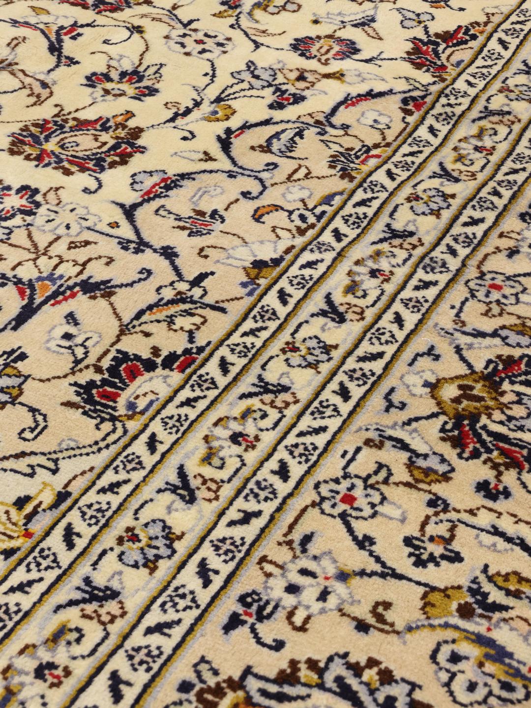 A large hand-knotted Keshan rug from the Middle East in beige with floral patterns.