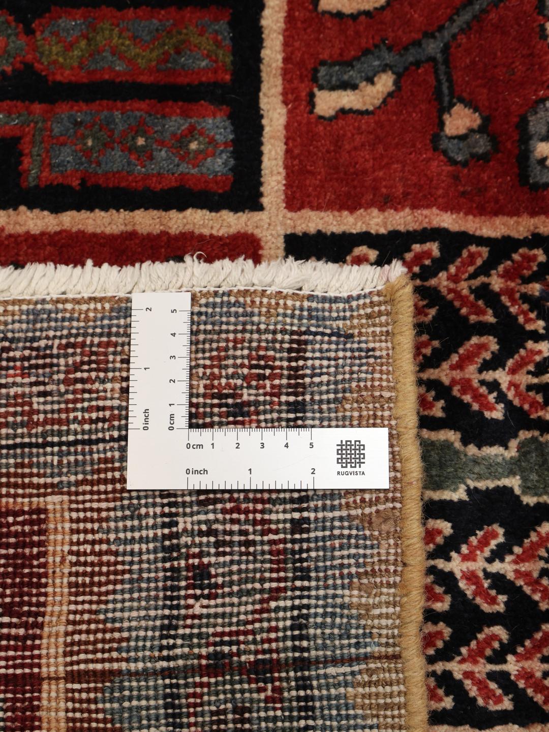 Et håndknyttet Bakhtiari-tæppe fra Mellemøsten med et rødt og blåt havepaneldesign.
