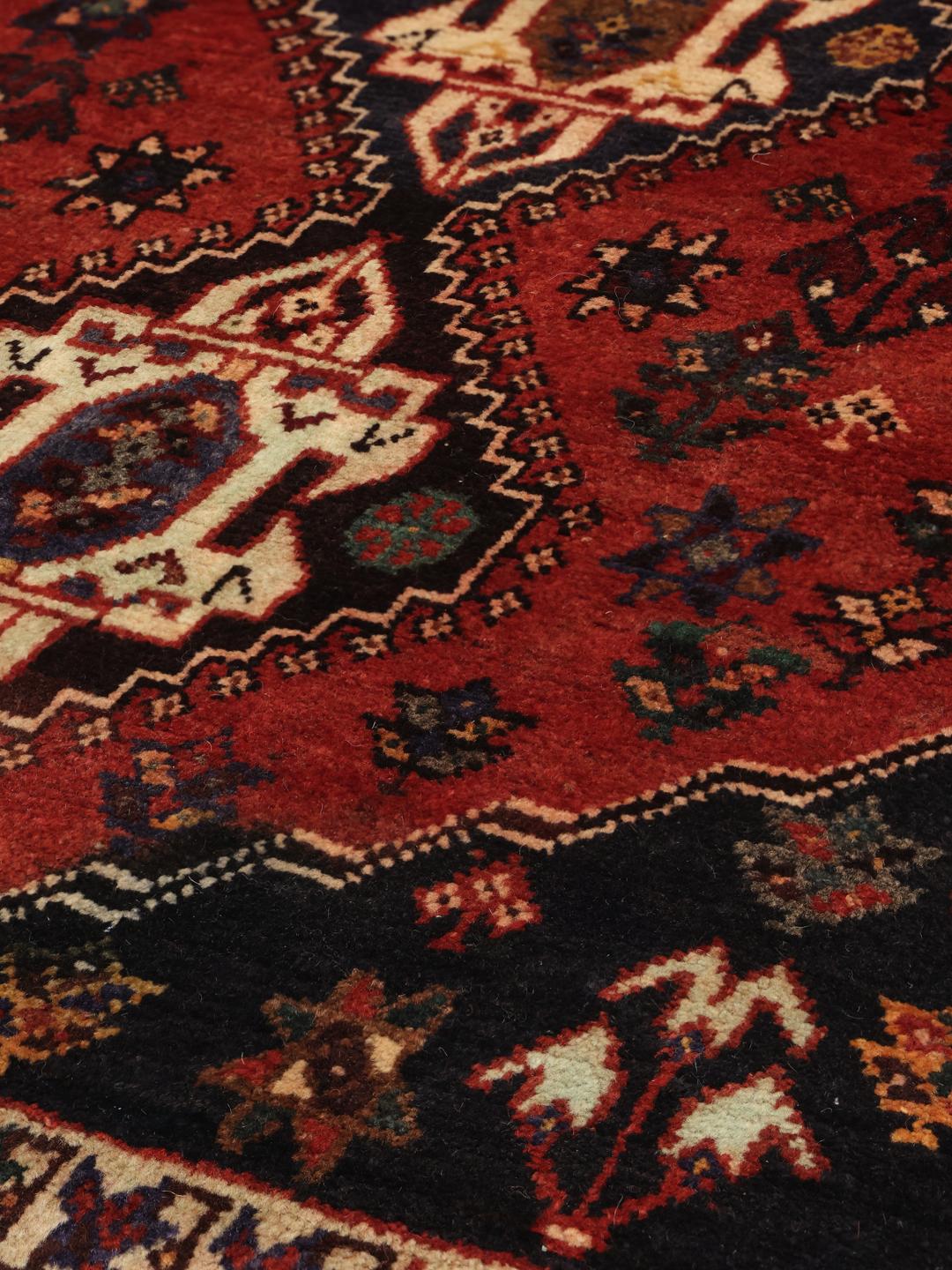 Hand-knotted Ghashghai rug from the Middle East featuring a red and dark blue geometric design