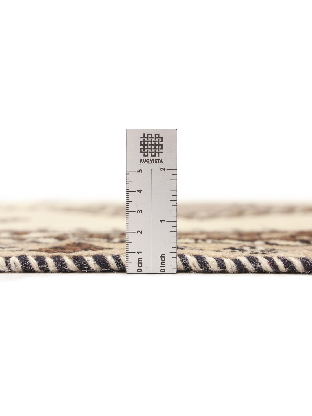 A hand-knotted Shiraz rug from the Middle East featuring geometric patterns in brown and beige.