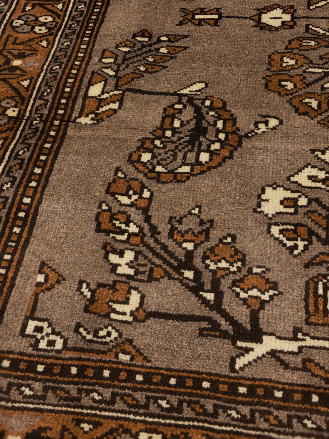 A hand-knotted Shiraz rug from the Middle East featuring brown floral motifs.
