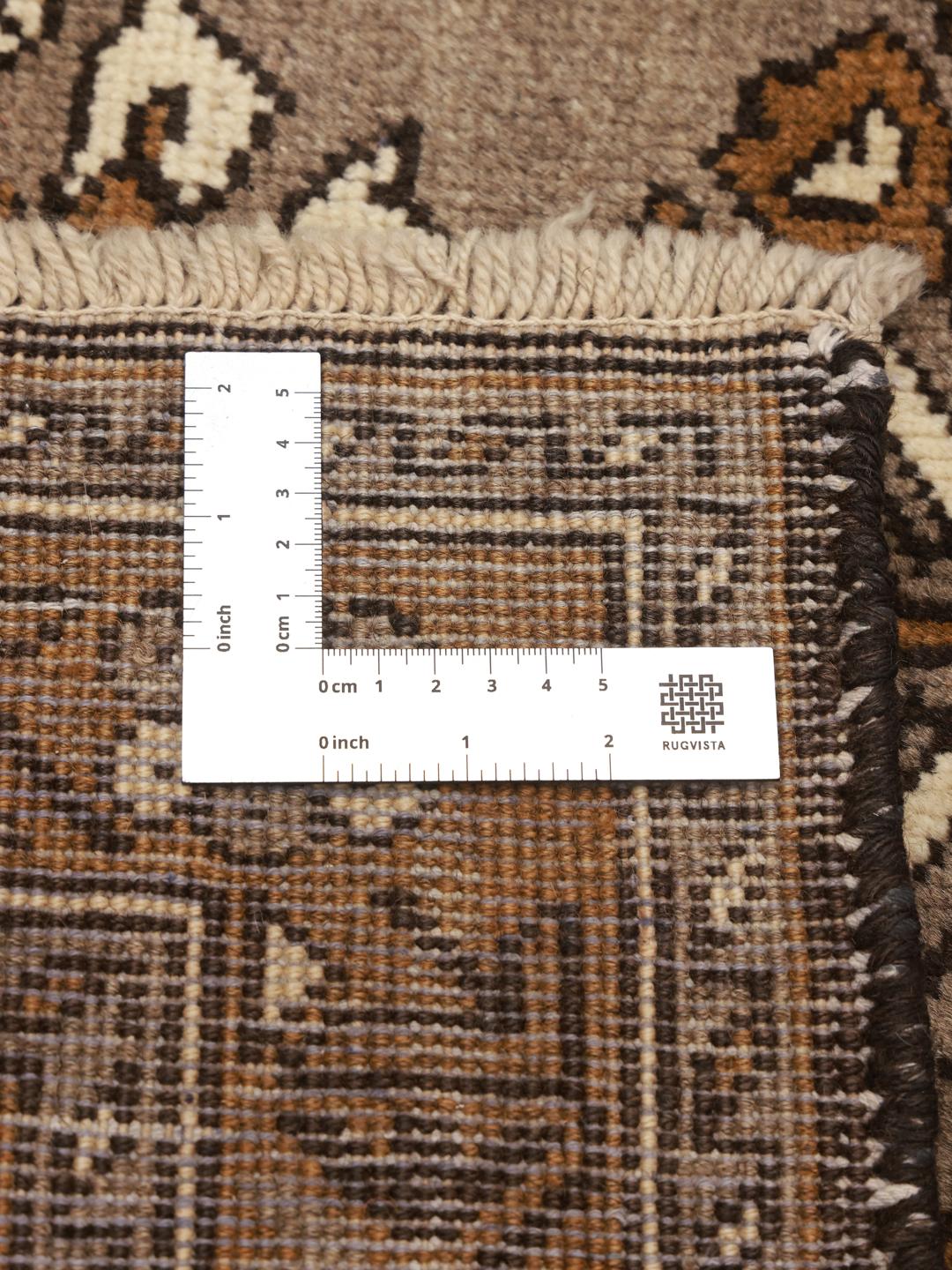 A hand-knotted Shiraz rug from the Middle East featuring brown floral motifs.