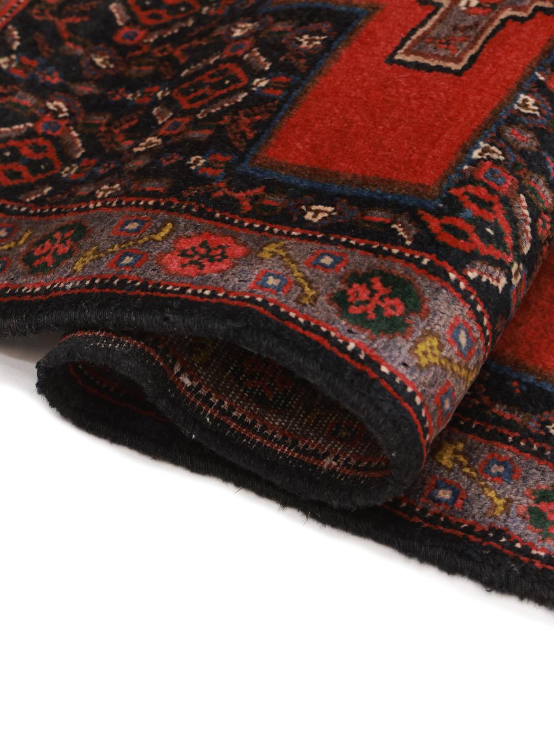 A hand-knotted Senneh rug from the Middle East with a bold red and black geometric design.