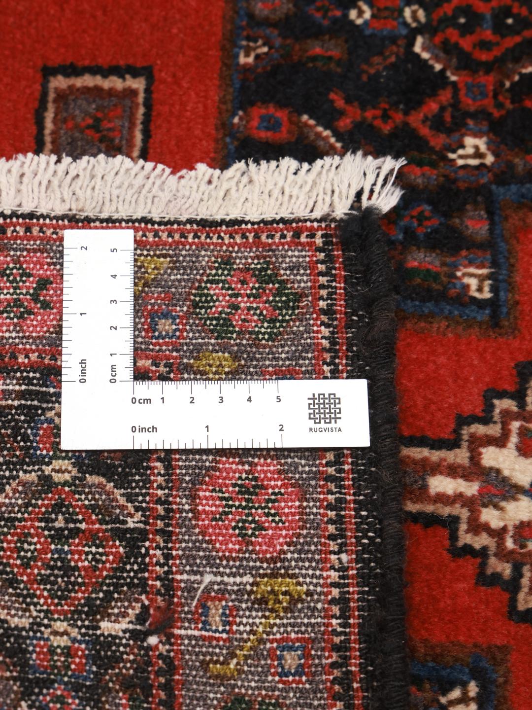 A hand-knotted Senneh rug from the Middle East with a bold red and black geometric design.