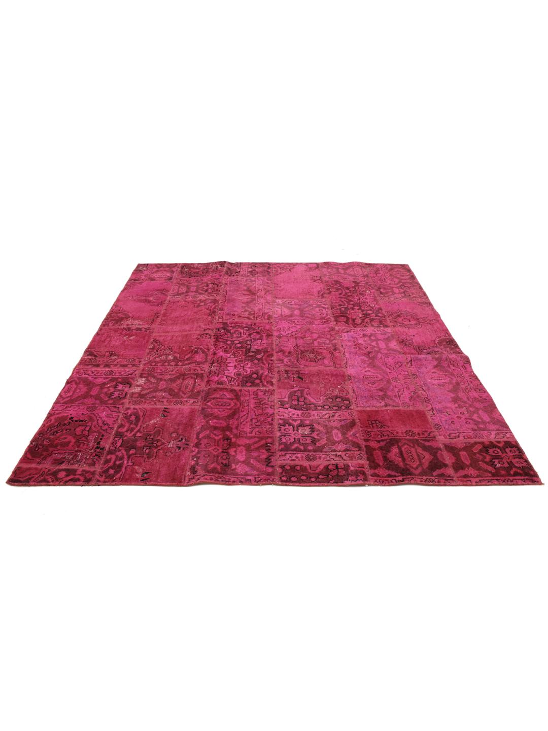 Een levendig vierkant patchwork tapijt met dieproze en rode tinten, handgeknoopt in het Midden-Oosten.