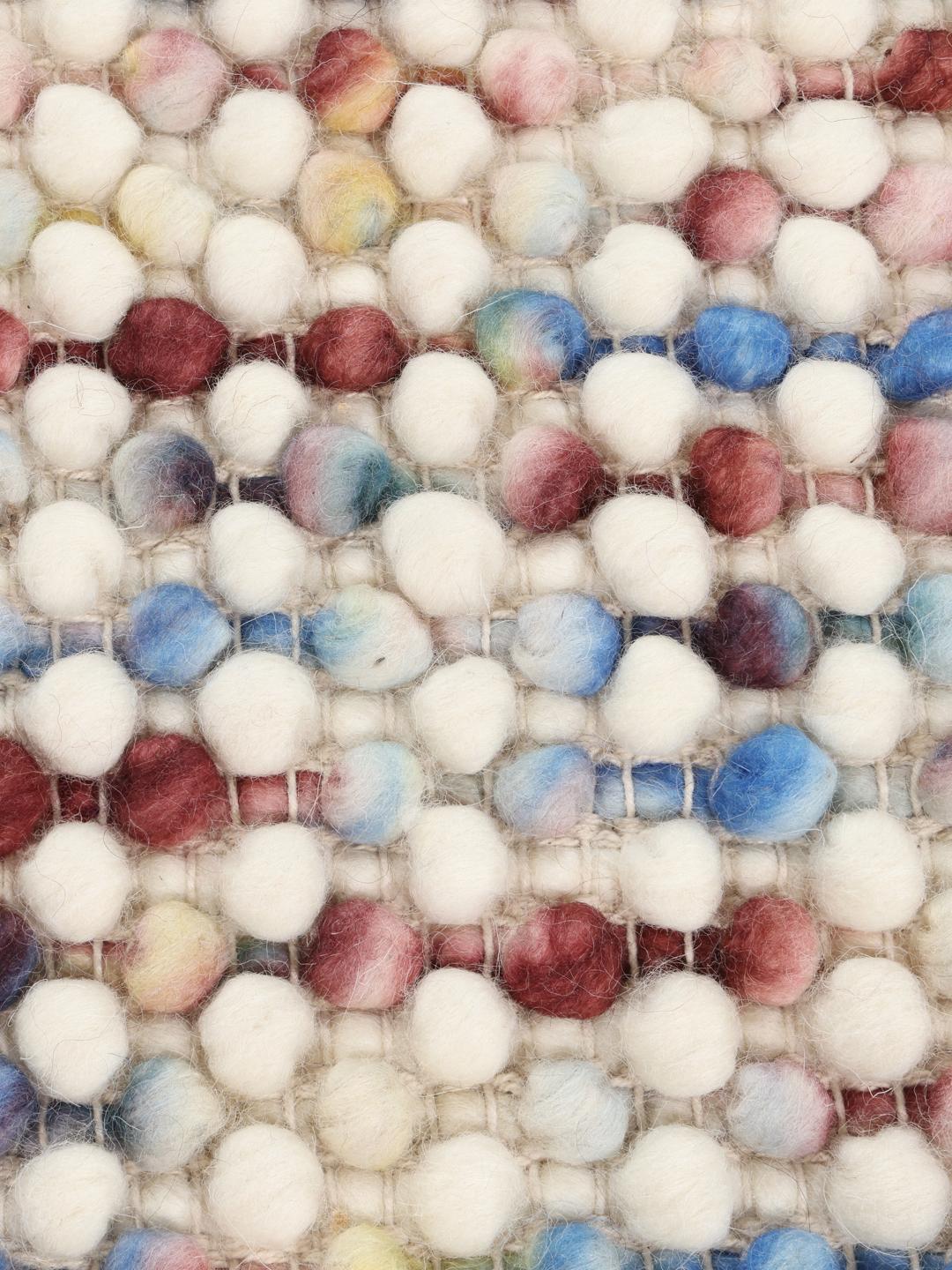 Et blødt uldtæppe i multicolor med en struktureret, håndvævet tekstur.