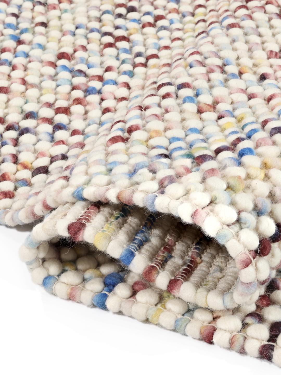 Et blødt uldtæppe i multicolor med en struktureret, håndvævet tekstur.