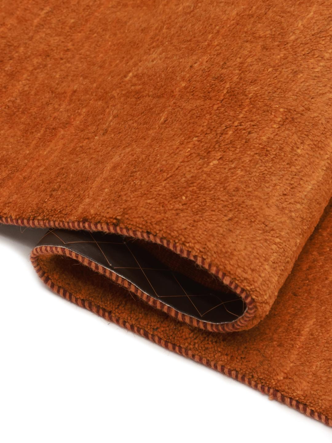 Een warm, oranje Gabbeh-tapijt uit het Midden-Oosten met een zachte, pluche textuur.