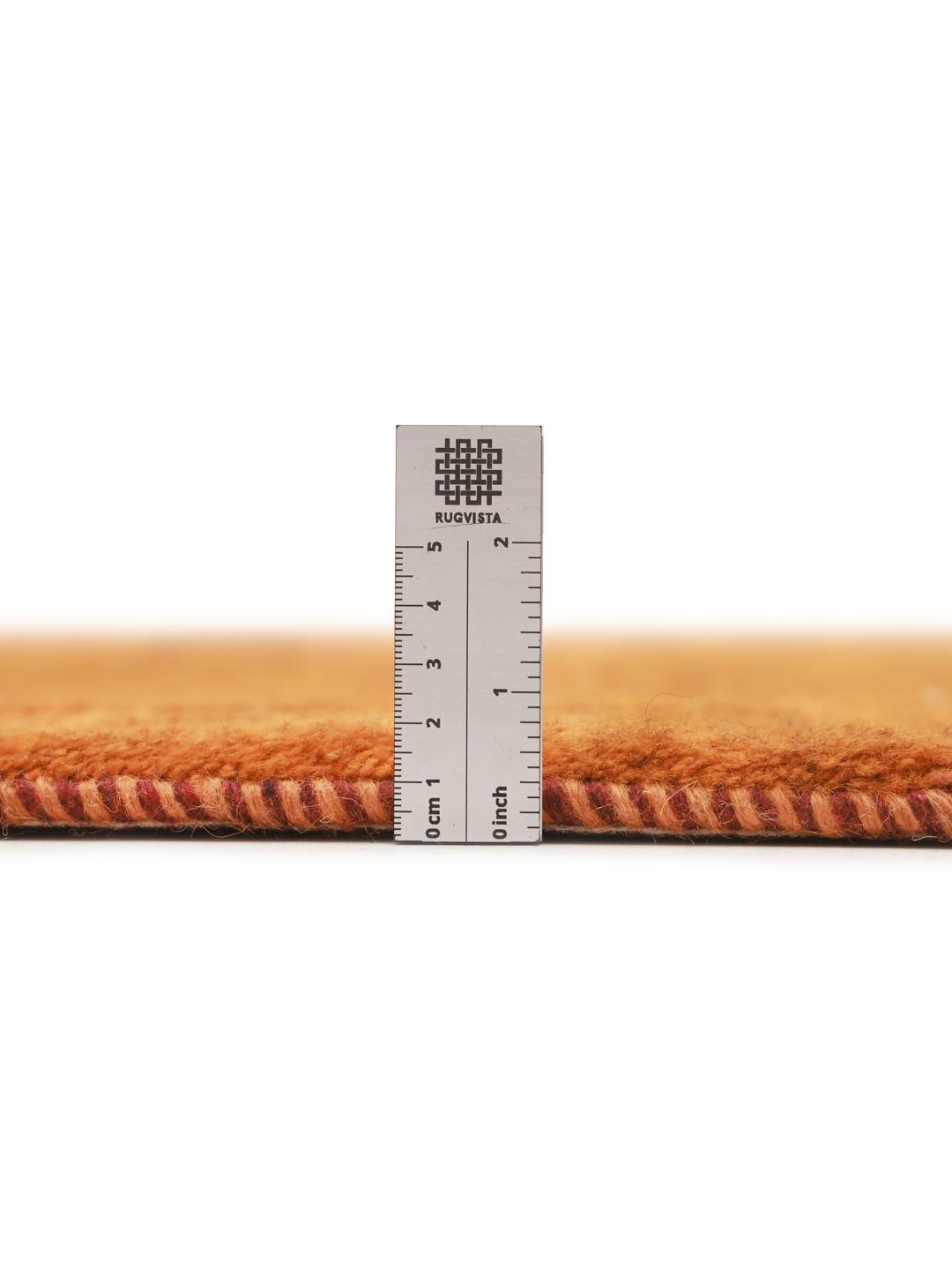 Een warm, oranje Gabbeh-tapijt uit het Midden-Oosten met een zachte, pluche textuur.