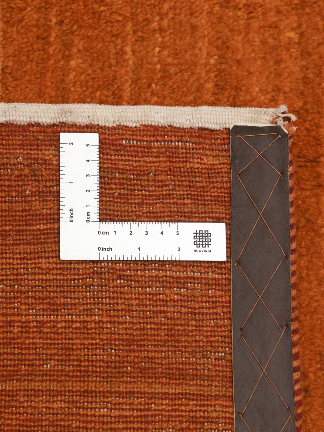 Een warm, oranje Gabbeh-tapijt uit het Midden-Oosten met een zachte, pluche textuur.