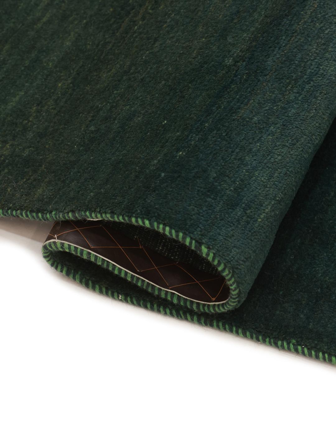 Hand-knotted Gabbeh rug in dark green, originating from the Middle East.