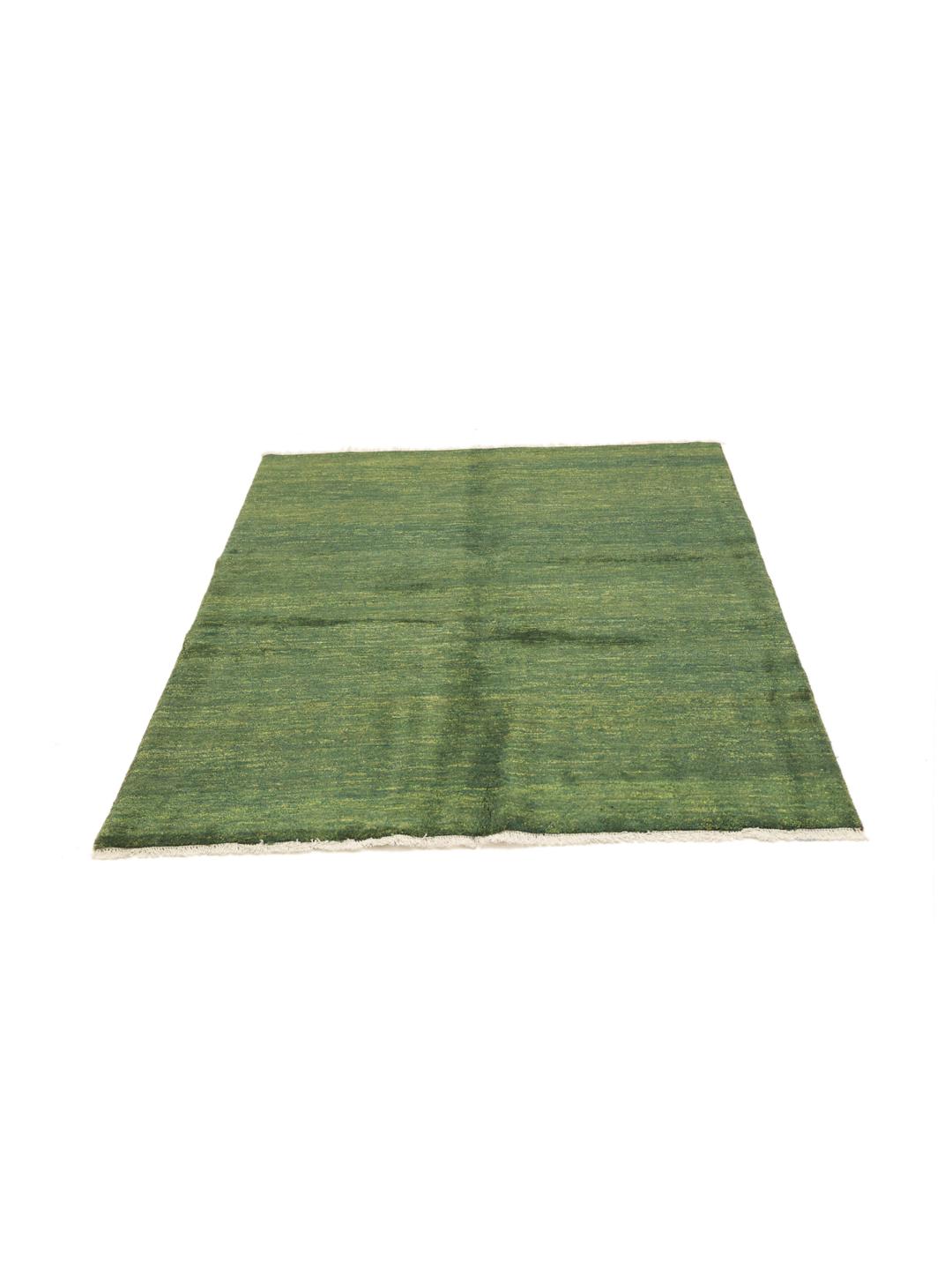 A hand-knotted Gabbeh rug from the Middle East in a deep, variegated dark-green colour.