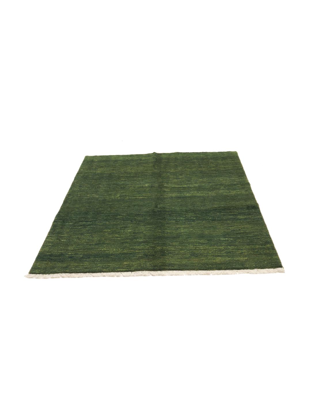 A hand-knotted Gabbeh rug from the Middle East in a deep, variegated dark-green colour.