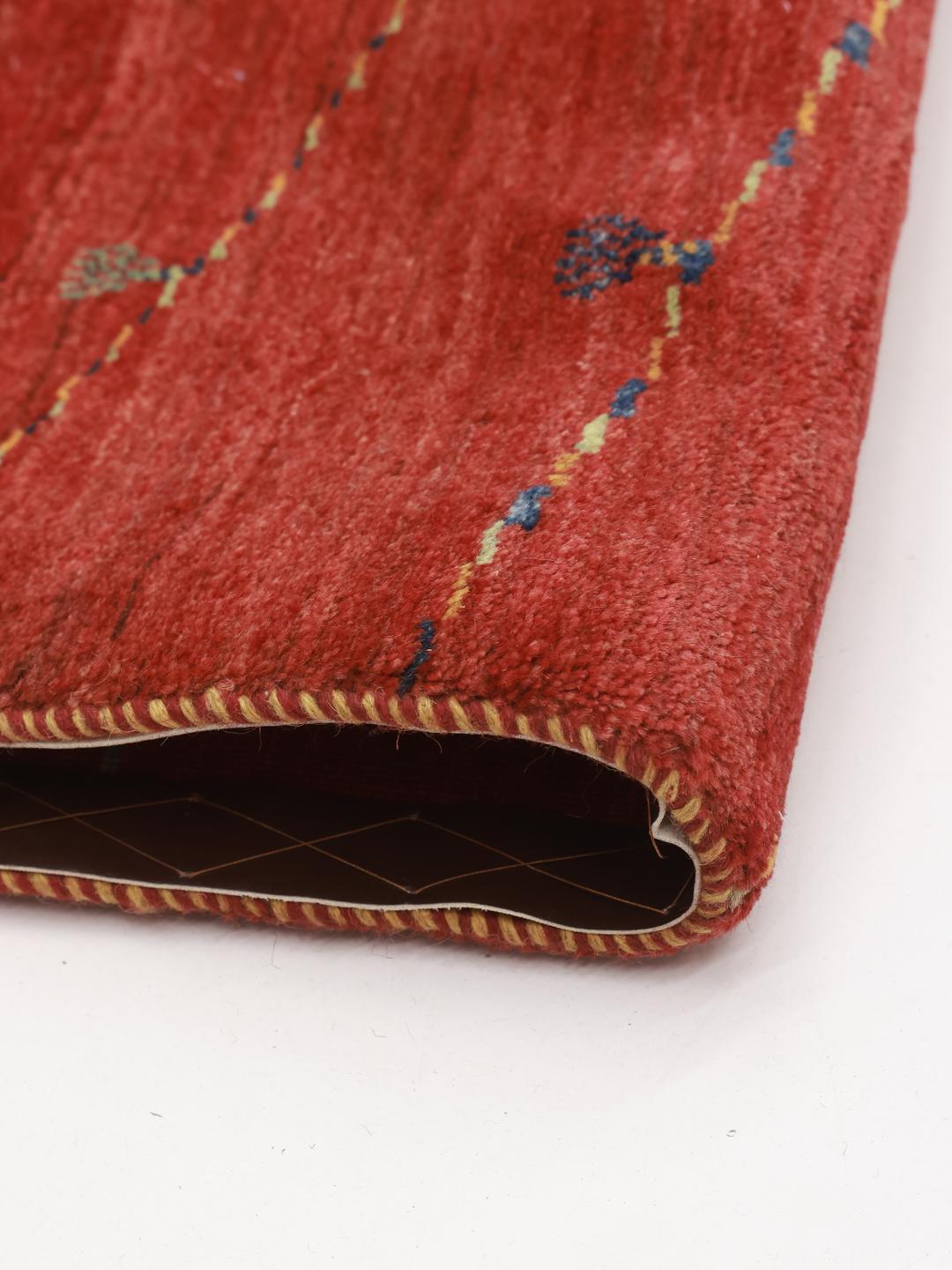Hand-knotted Gabbeh rug from the Middle East in a deep red colour