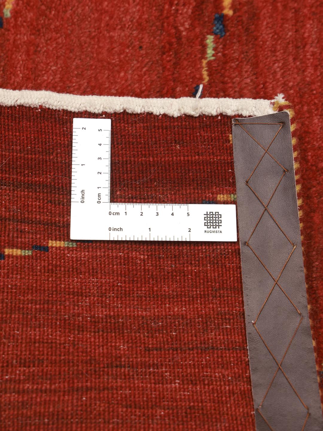 Hand-knotted Gabbeh rug from the Middle East in a deep red colour