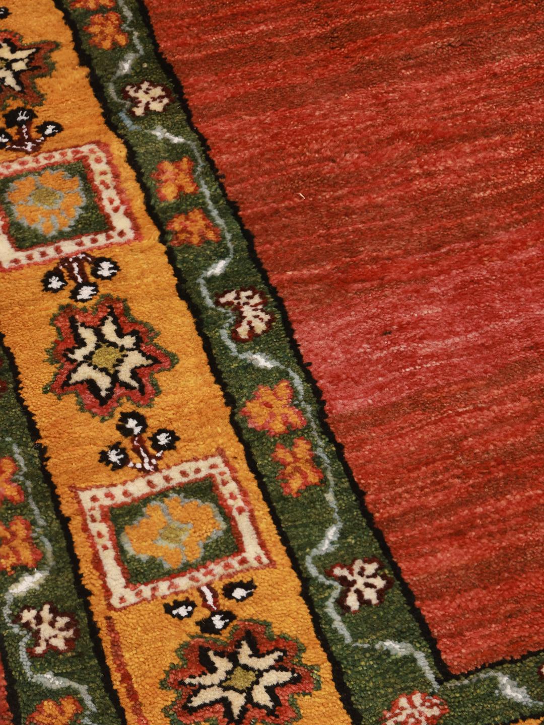 Hand-knotted Gabbeh rug with a red field and decorative border from the Middle East