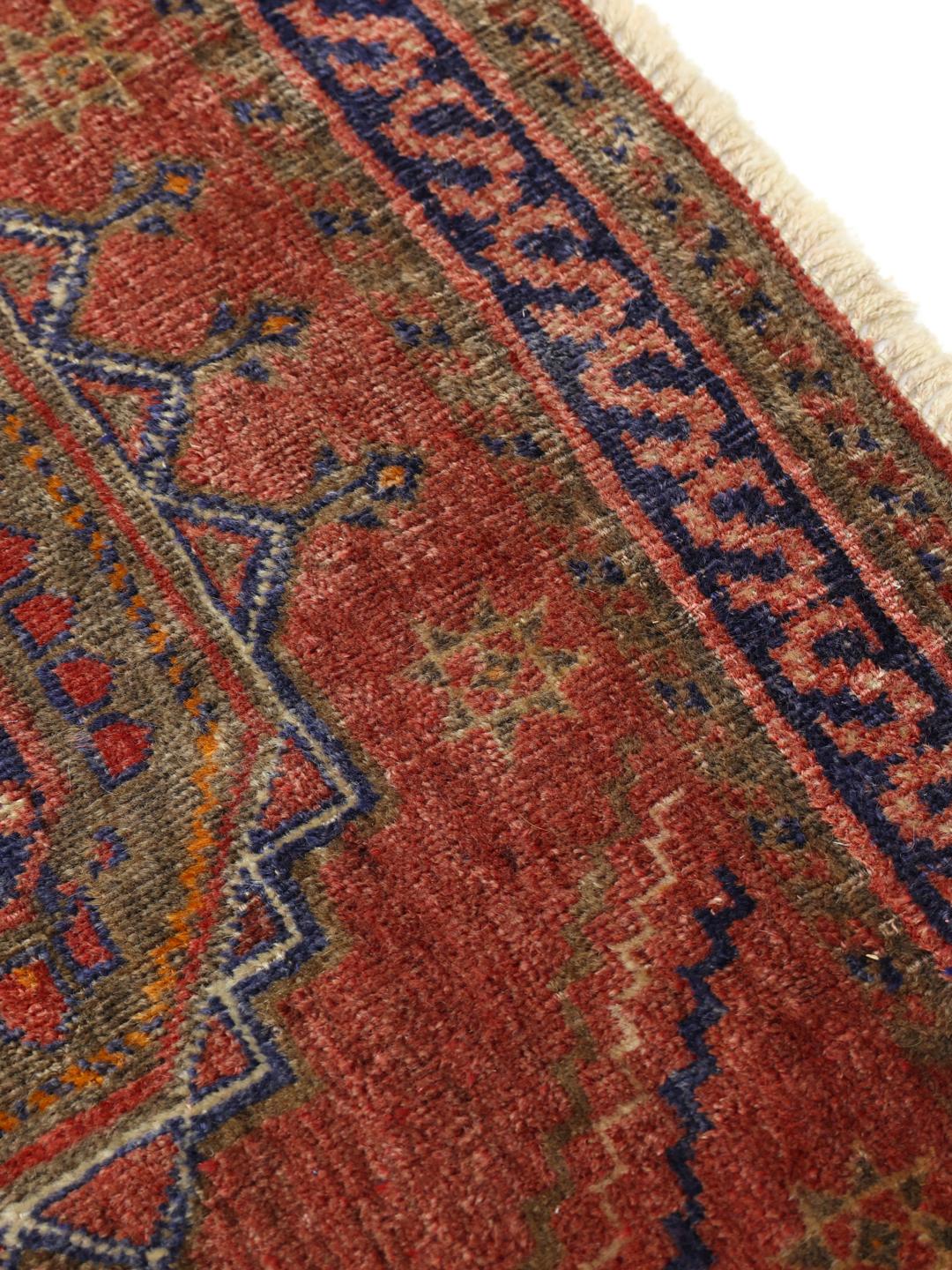 Hand-knotted red rug from the Middle East with a unique patina finish