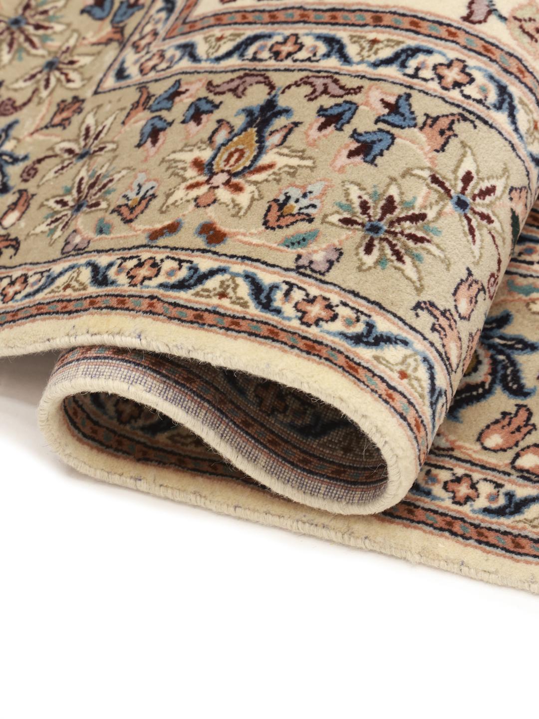 A hand-knotted Keshan rug from the Middle East with a beige field and floral patterns.