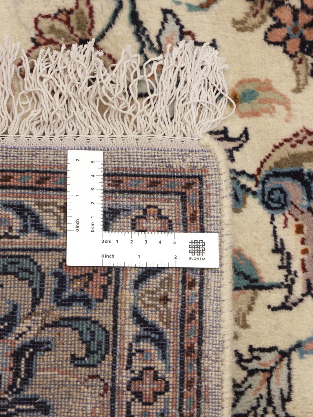 A hand-knotted Keshan rug from the Middle East with a beige field and floral patterns.