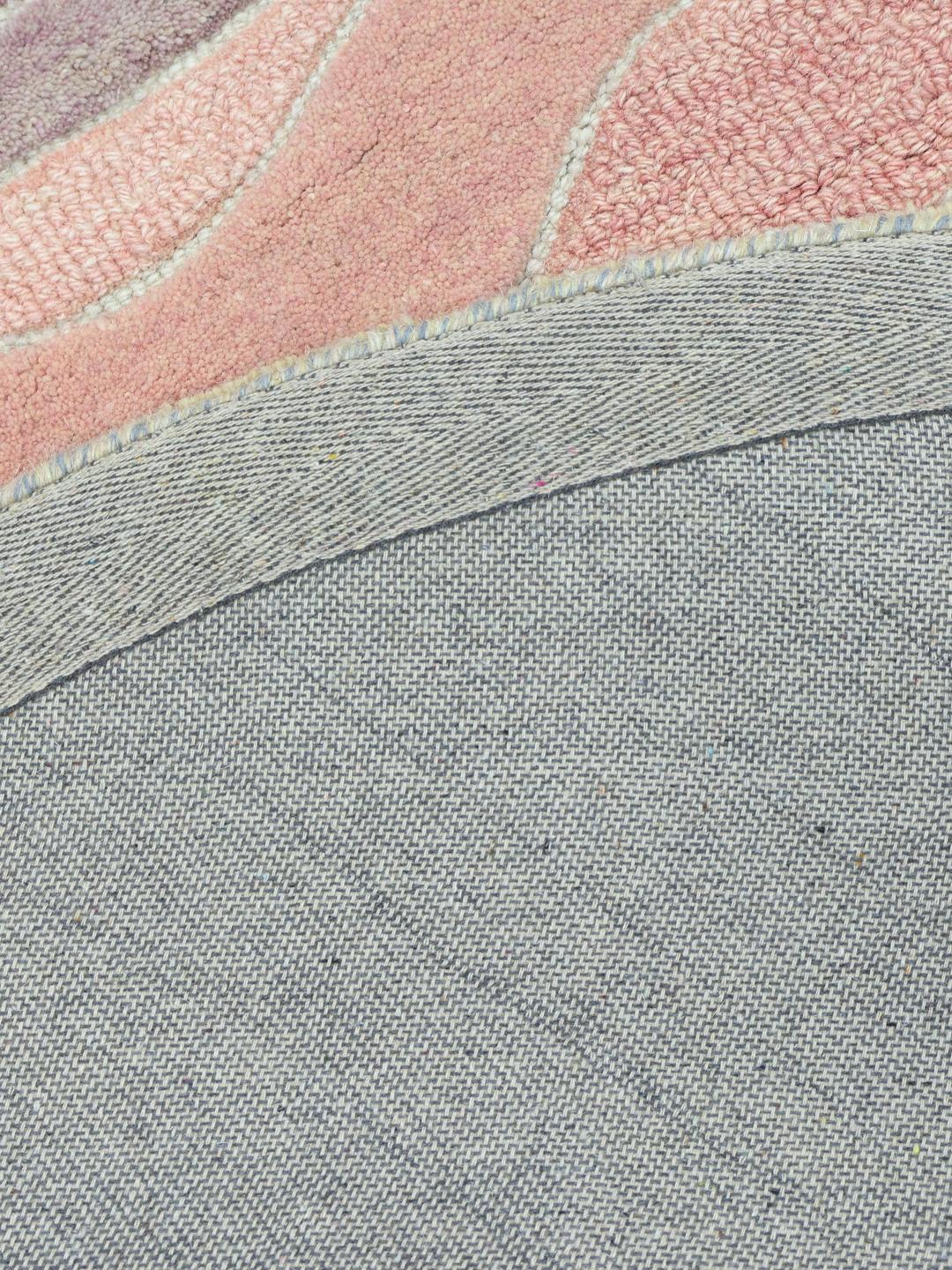 Een rond meerkleurig tapijt met organische, vloeiende lijnen in zachte pastel- en aardetinten.