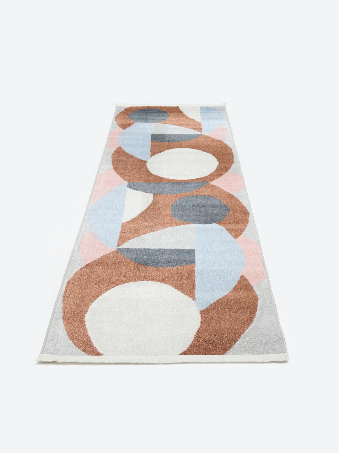 En moderne løber med et geometrisk mønster i terracotta og røde nuancer.