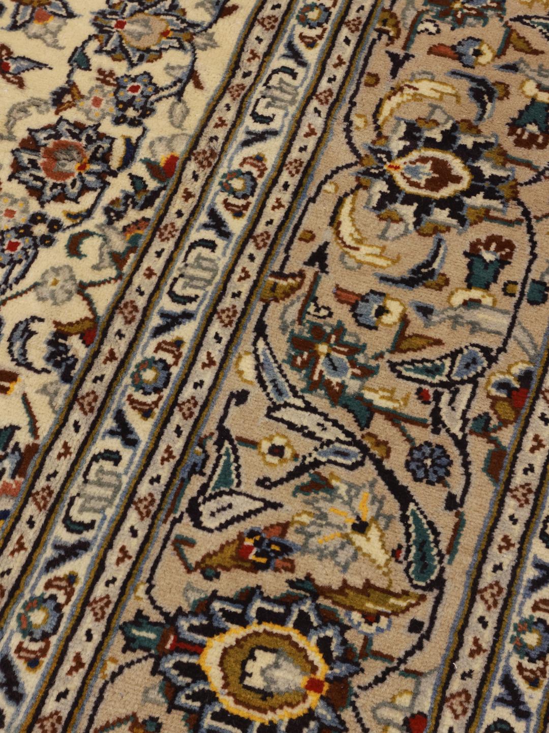 A rectangular hand-knotted Keshan rug from the Middle East in beige tones with floral patterns.