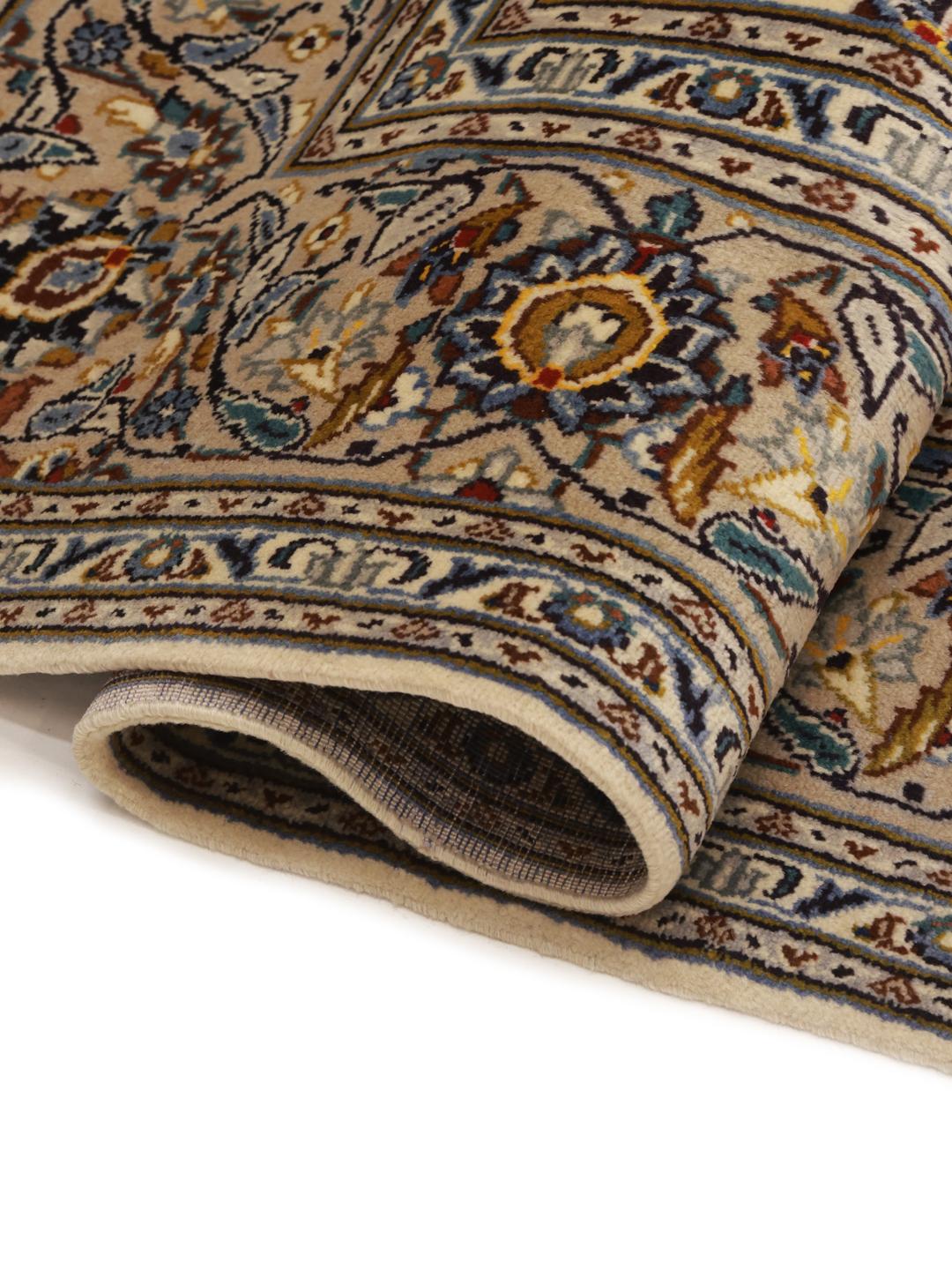 A rectangular hand-knotted Keshan rug from the Middle East in beige tones with floral patterns.