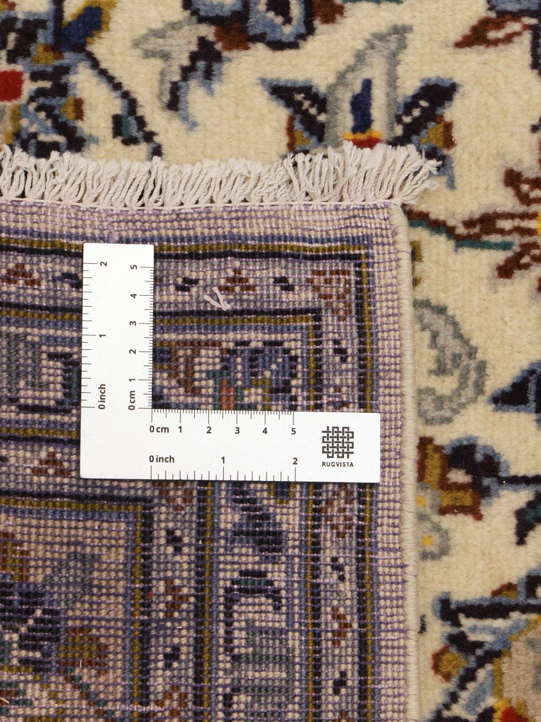 A rectangular hand-knotted Keshan rug from the Middle East in beige tones with floral patterns.