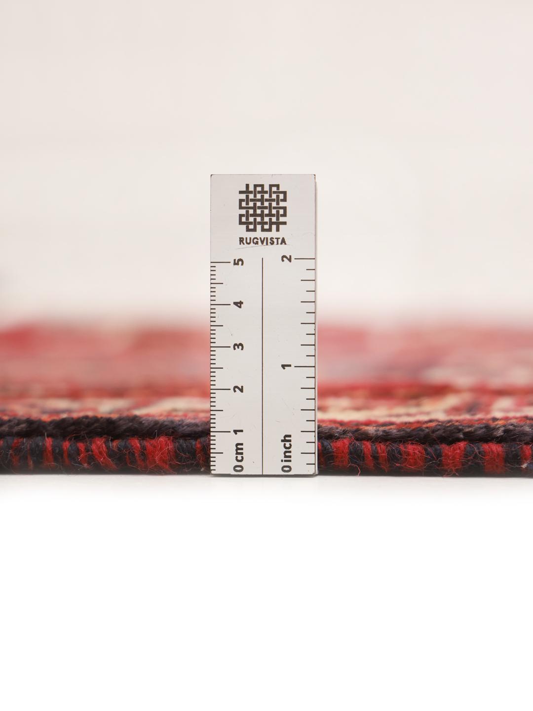 A hand-knotted Shiraz rug from the Middle East featuring a vibrant red field and bold geometric medallion patterns.