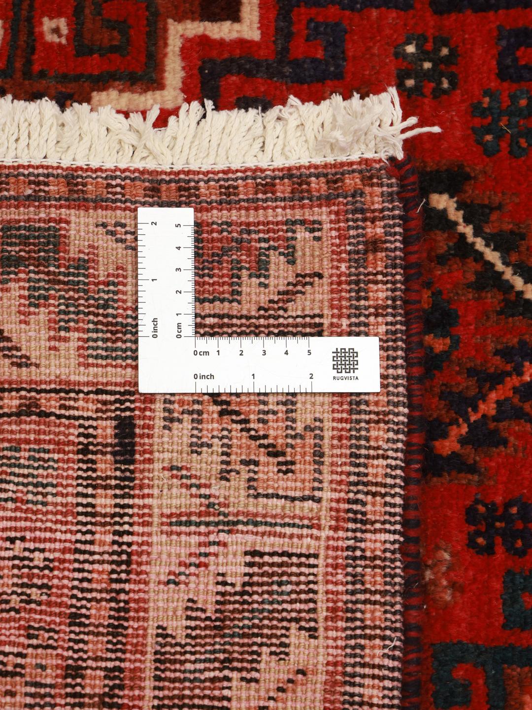 A hand-knotted Shiraz rug from the Middle East featuring a vibrant red field and bold geometric medallion patterns.