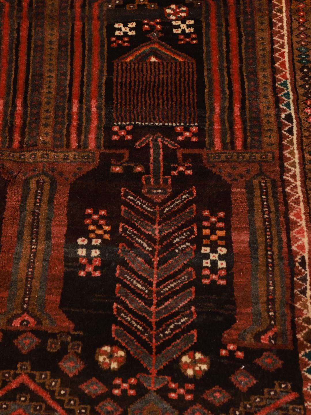 Hand-knotted Middle Eastern rug in dark-red and black with tribal patterns