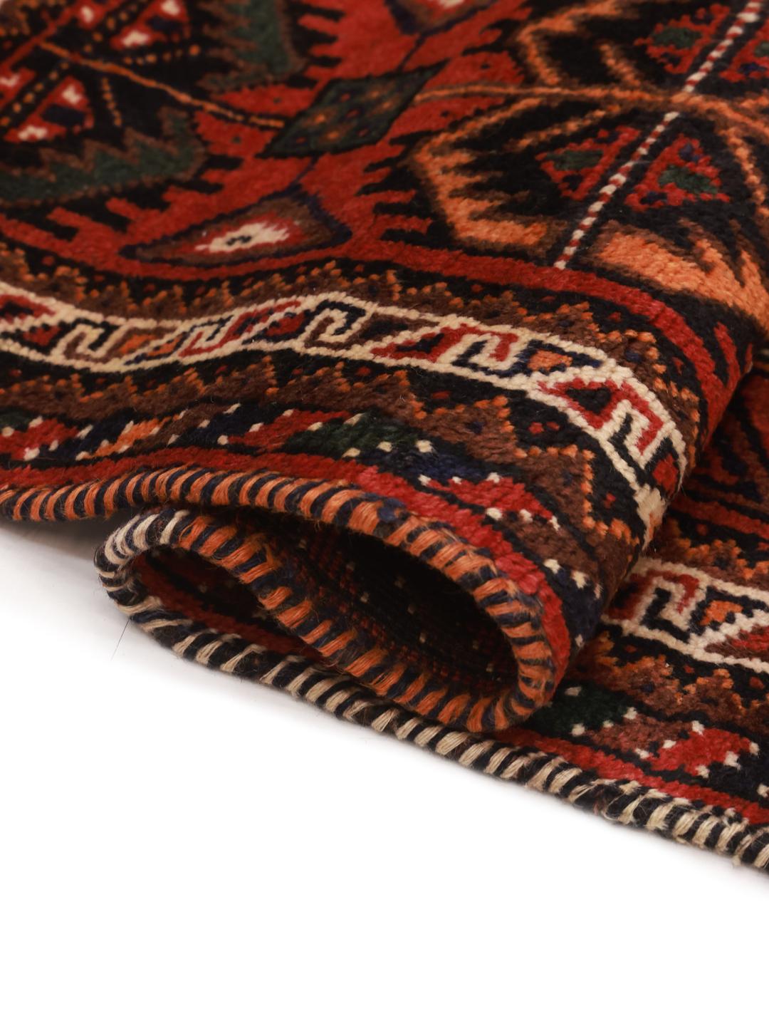 Hand-knotted Shiraz rug from the Middle East featuring a vibrant red field and tribal geometric patterns.