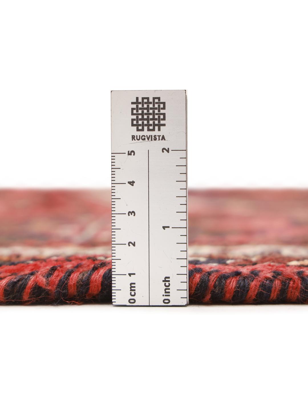 Hand-knotted Shiraz rug from the Middle East featuring a vibrant red field and tribal geometric patterns.