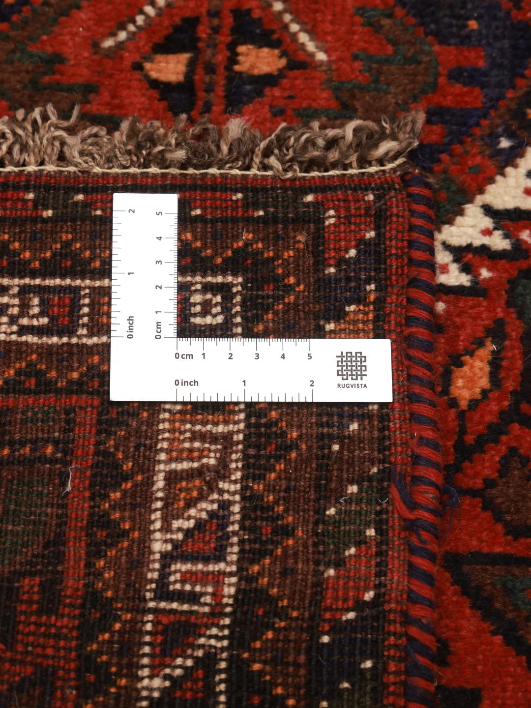 Hand-knotted Shiraz rug from the Middle East featuring a vibrant red field and tribal geometric patterns.