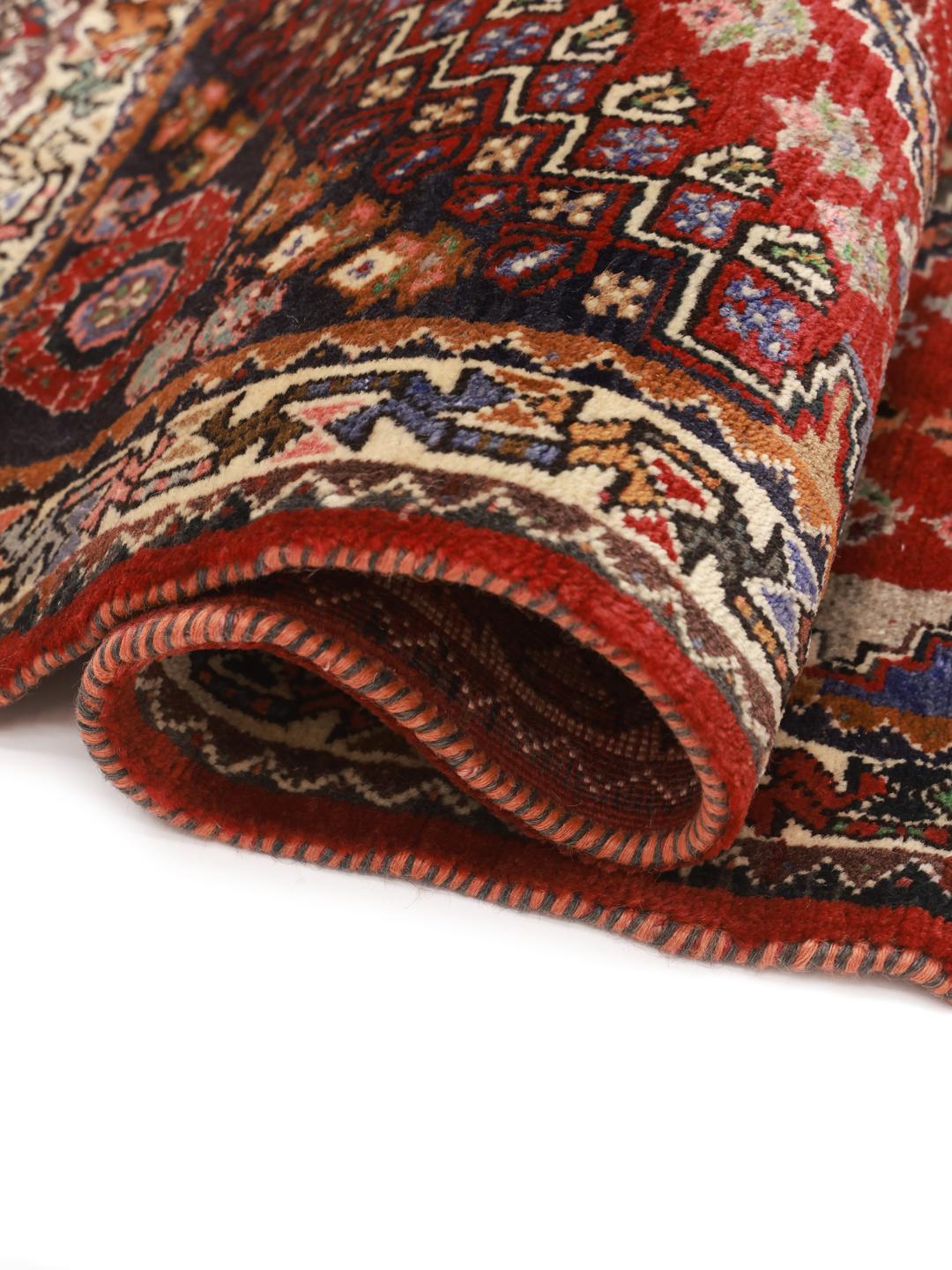 Hand-knotted red Ghashghai rug featuring tribal geometric motifs