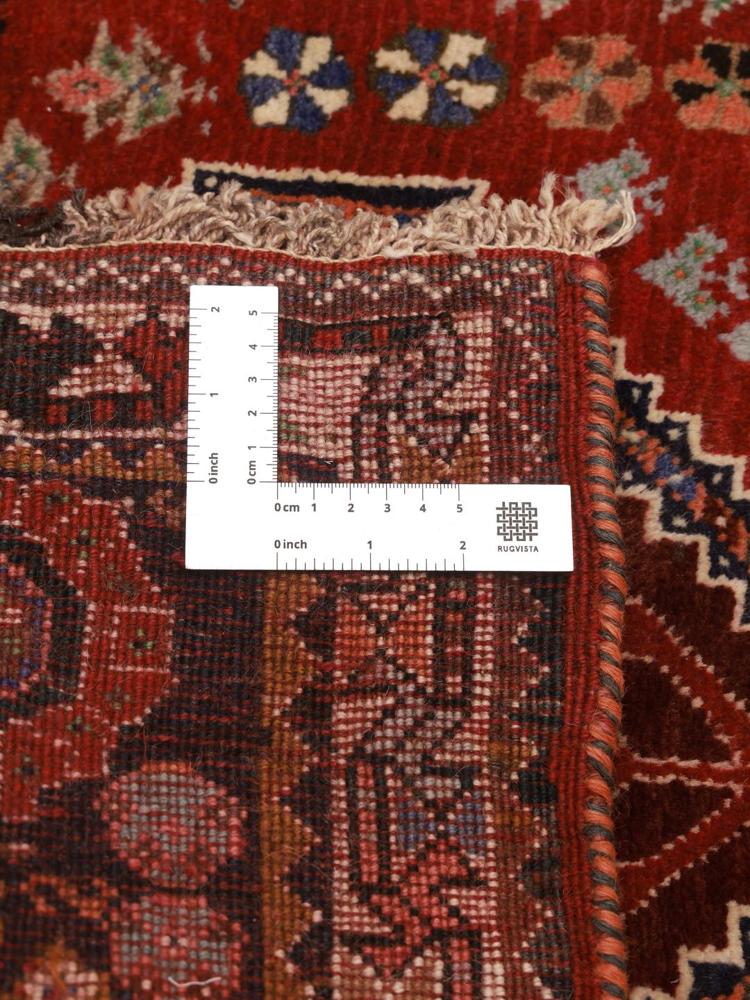 Hand-knotted red Ghashghai rug featuring tribal geometric motifs