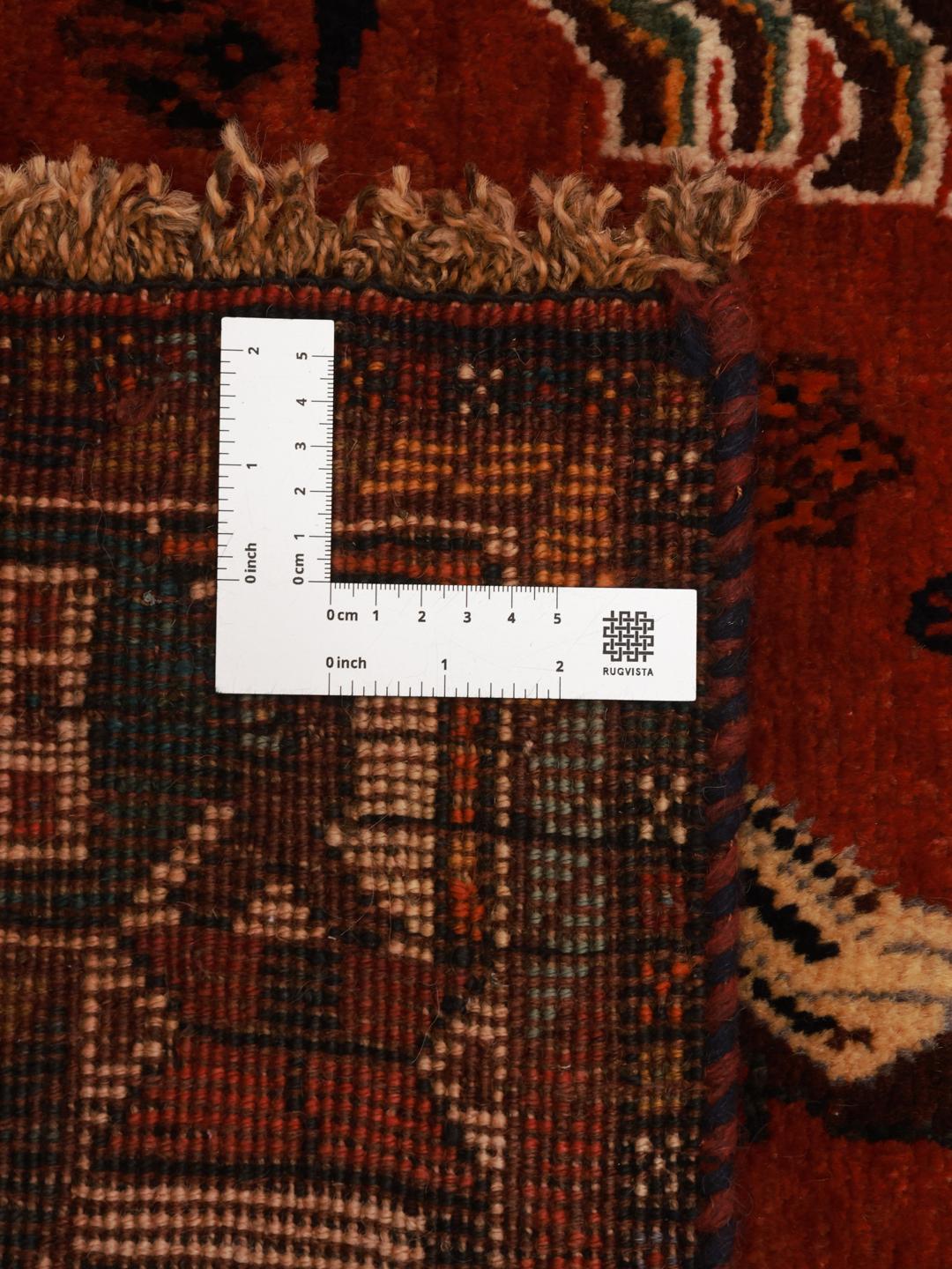 A unique hand-knotted Ghashghai rug from the Middle East with a vibrant red field and animal motifs.