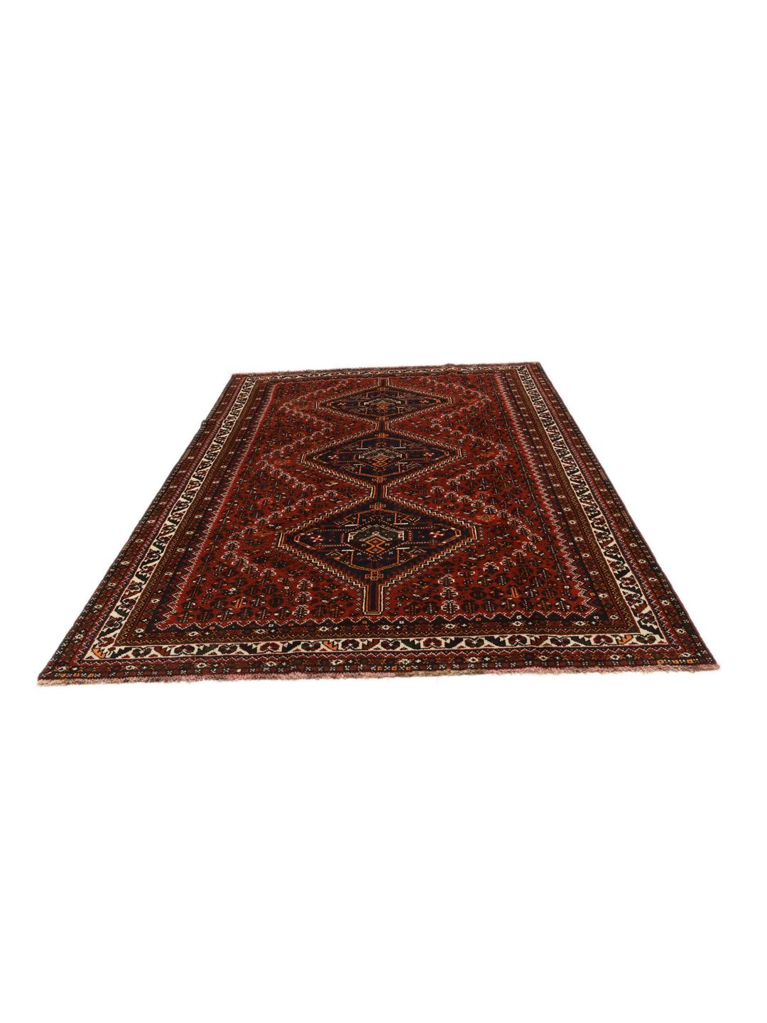 A hand-knotted Shiraz rug from the Middle East featuring a dark-red field with geometric medallions.