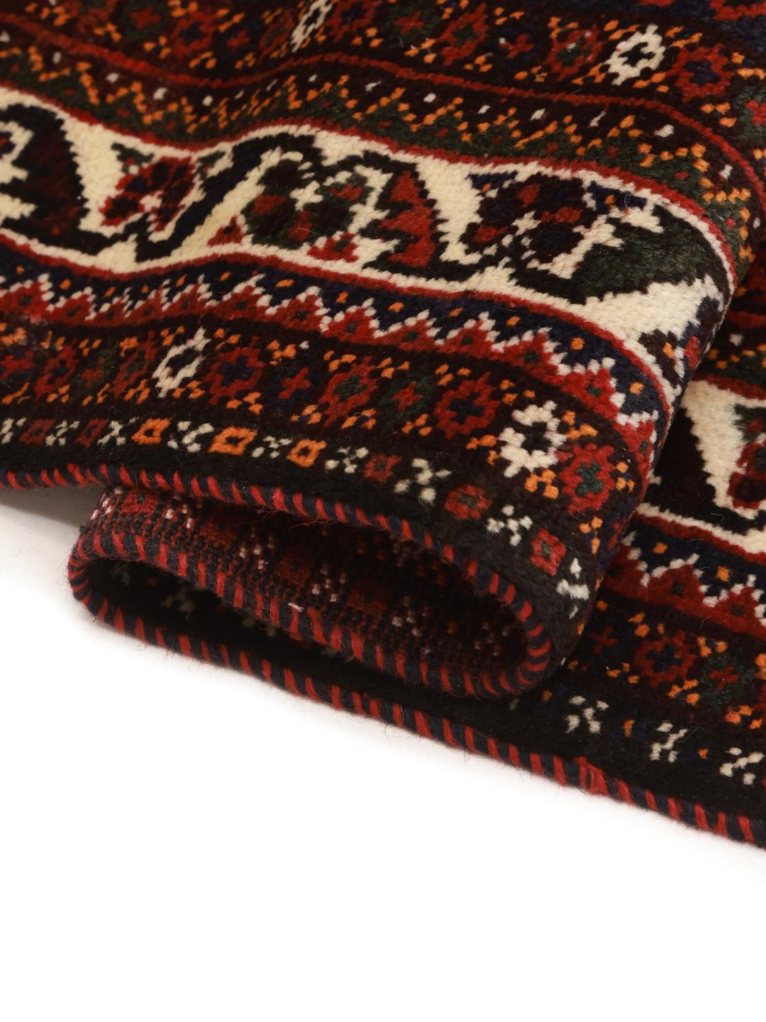 A hand-knotted Shiraz rug from the Middle East featuring a dark-red field with geometric medallions.